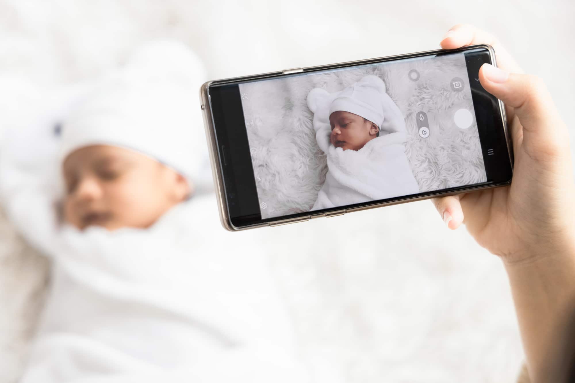 Parent viewing a sleeping baby via phone